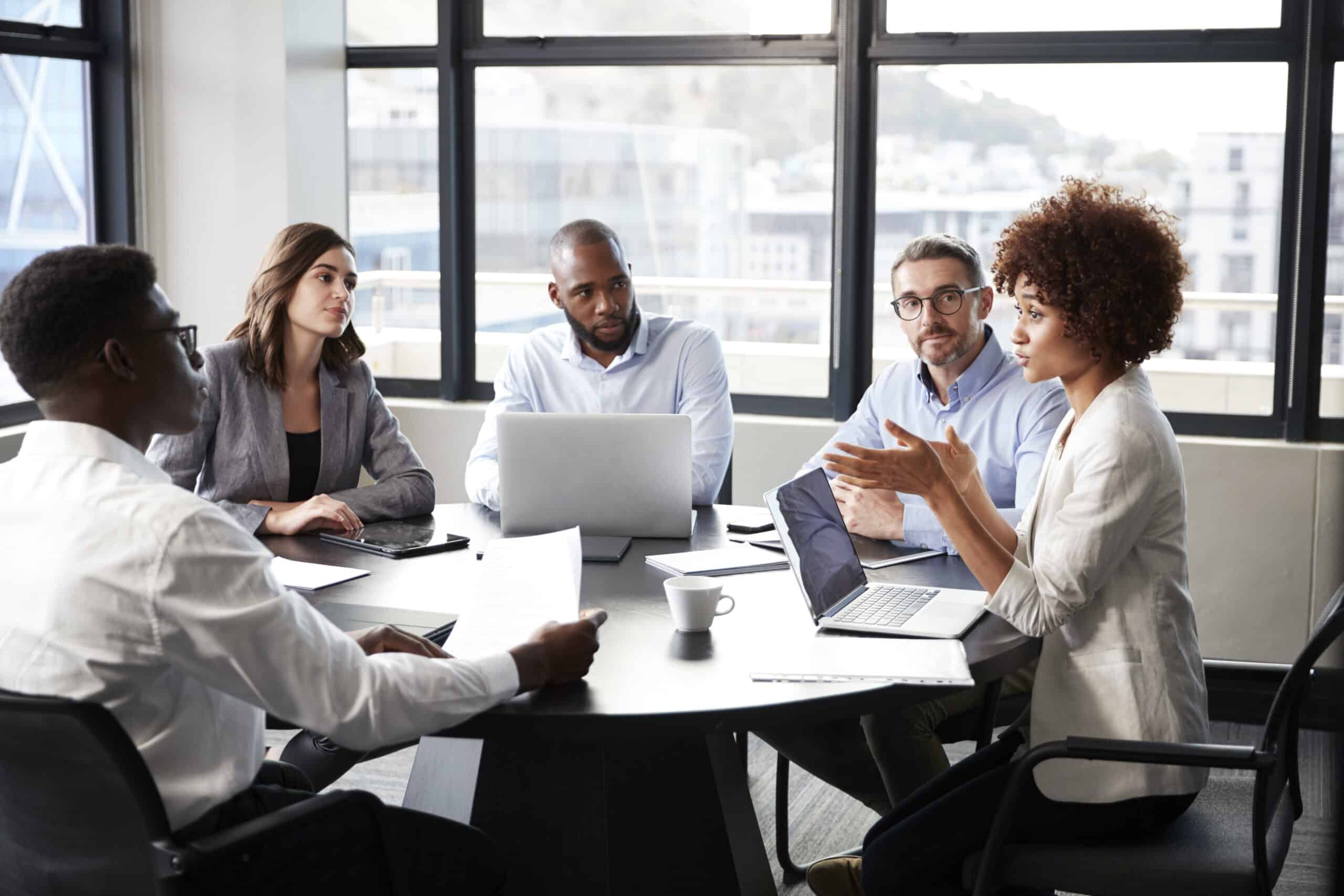 Millennial black businesswoman addressing colleagues at a corporate business meeting, close up