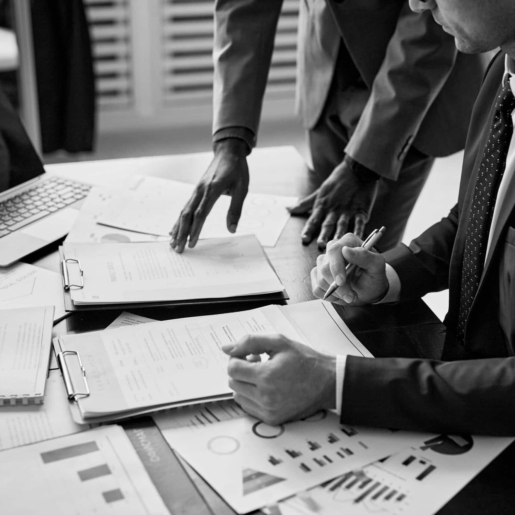 Cropped shot of two businessmen discussing contract at table during meeting in office, copy space